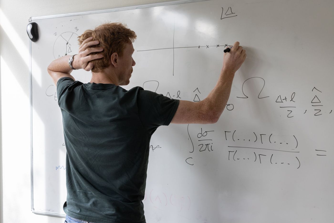 Researcher seen from behind working through a contour integral on a whiteboard
